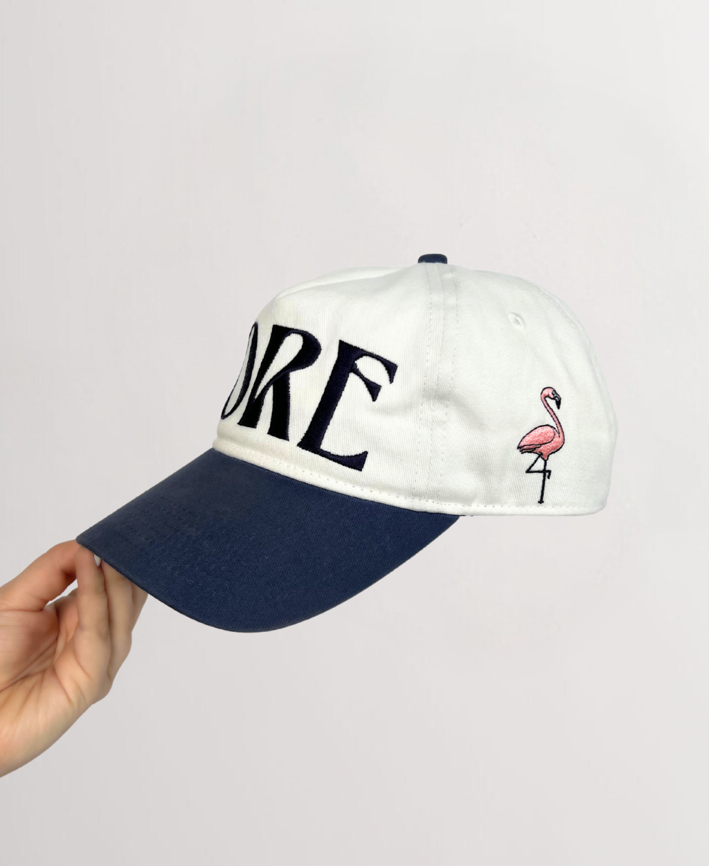 Front of ball cap with Indigo Stitching reading &quot;FORE&quot; on a white hat and Indigo hat brim showing embroidered  flamingo on RT side 