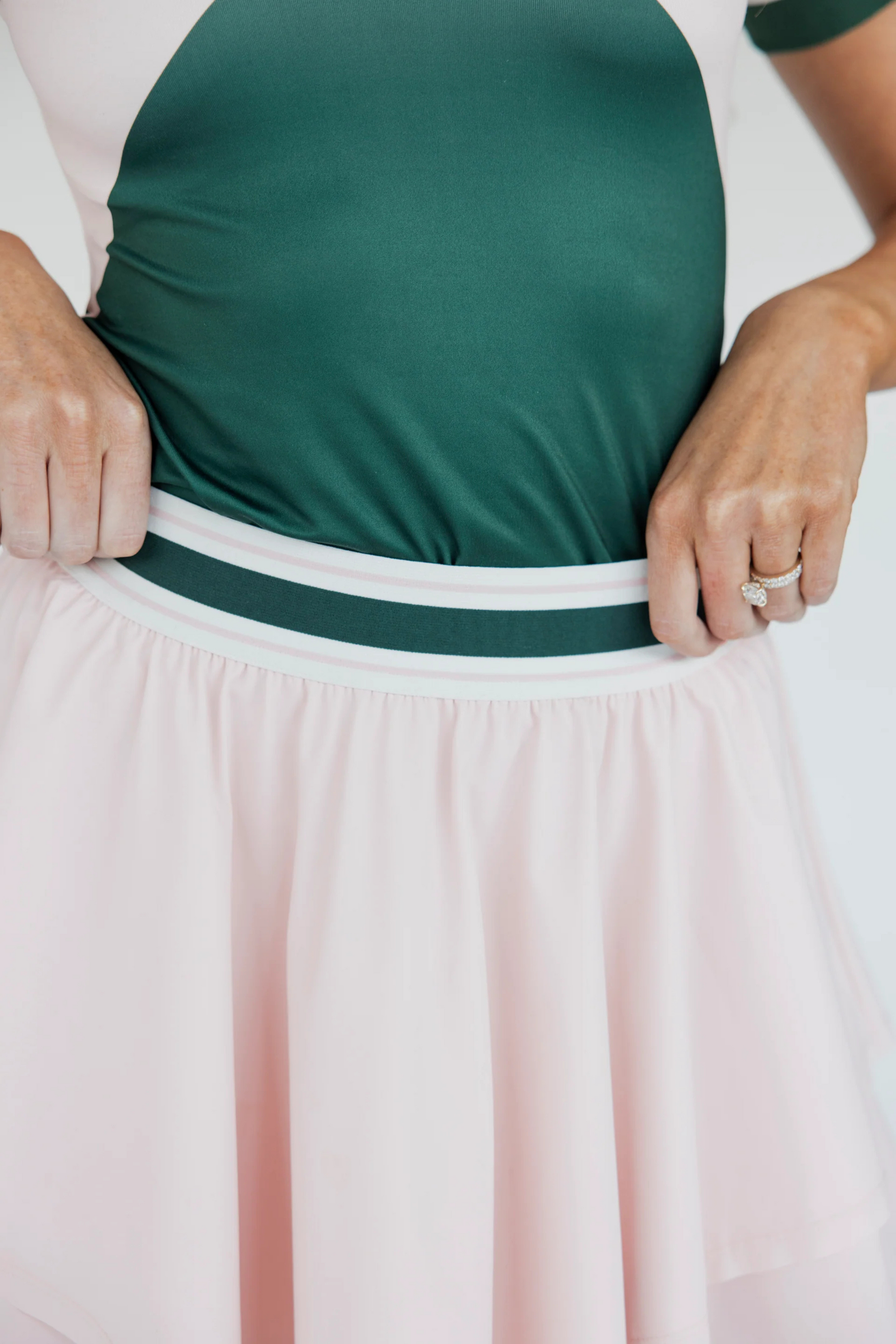 The "Rowie Skirt" is a versatile and timeless wardrobe essential for women. It features a flattering striped elastic waistband and a double-layered design that adds elegance and comfort. Made from stretchy, breathable fabric, this skirt allows for ease of movement, whether on the golf course or during casual outings. A stylish choice for any occasion.