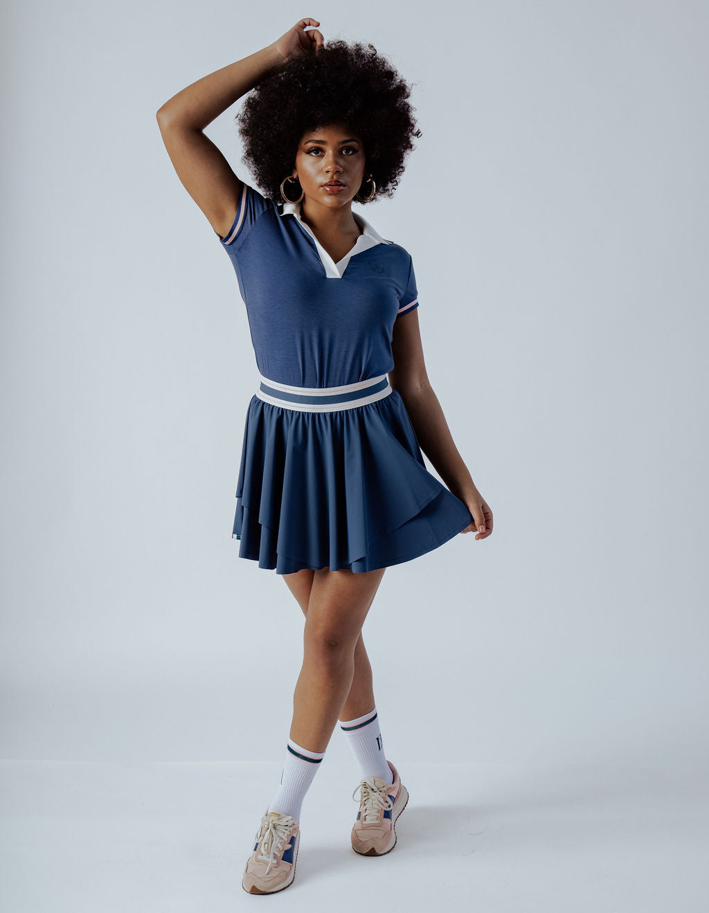 Blue Polo Shirt with white collar and form fitting and pink stripe on cap sleeve worn on a woman