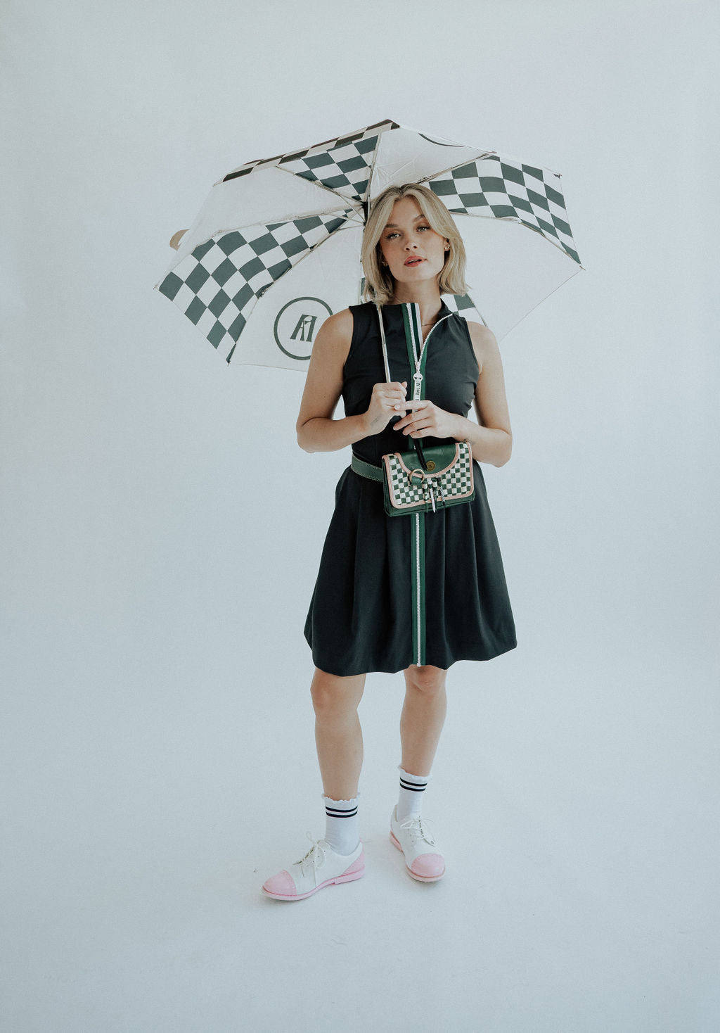 Girl holding a checkered black and cream umbrella