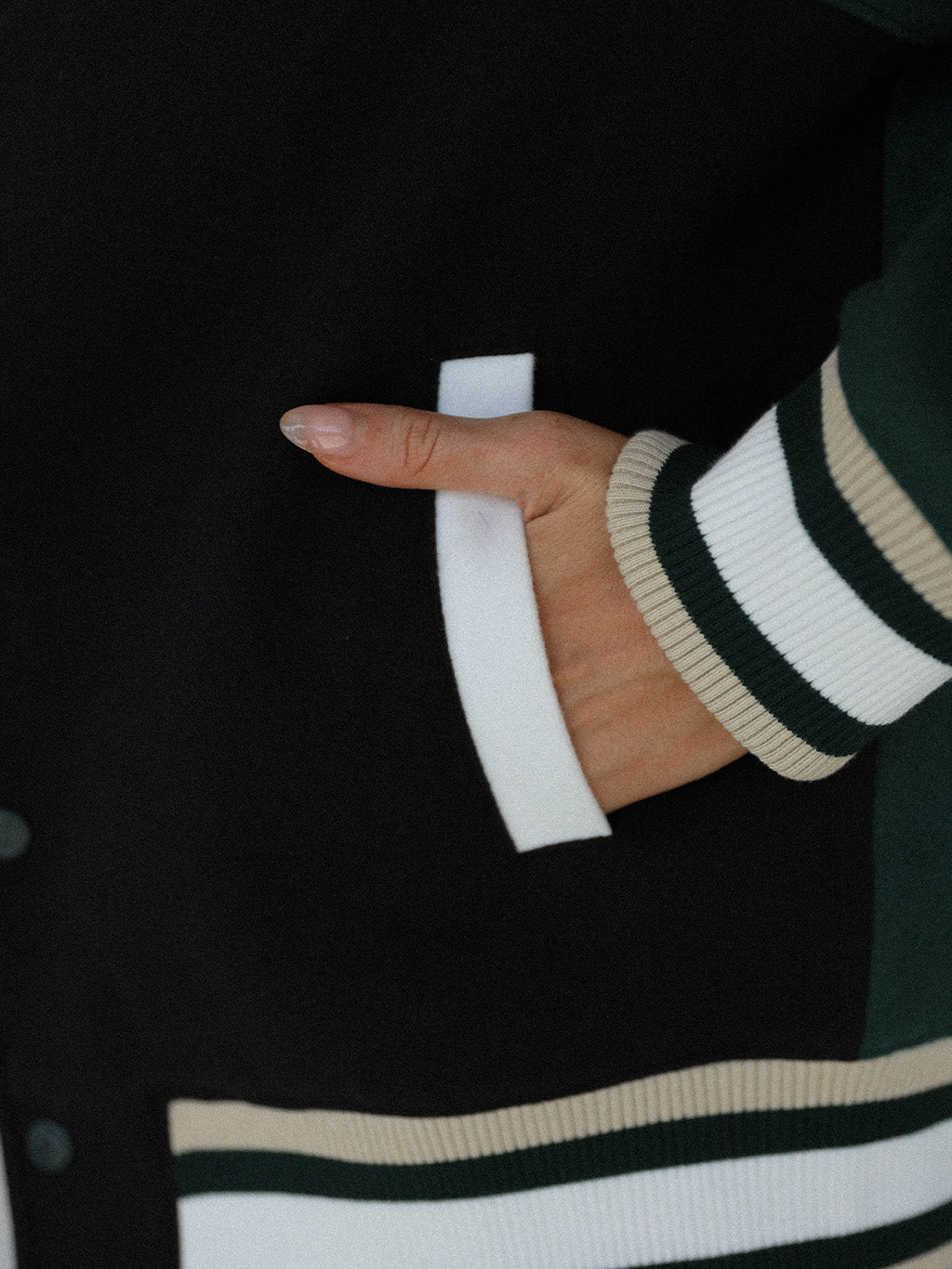 Close-up of the &#39;Captain&#39;s Jacket&#39; from the Royal Collection, showcasing its autumn-inspired hues. Features include exclusive capsule patches, color blocking, black/green checkered lining, and &#39;Fore All&#39; embroidery on the back. This vintage-inspired varsity jacket combines classic style with modern details, ideal for making a statement in your fall wardrobe.