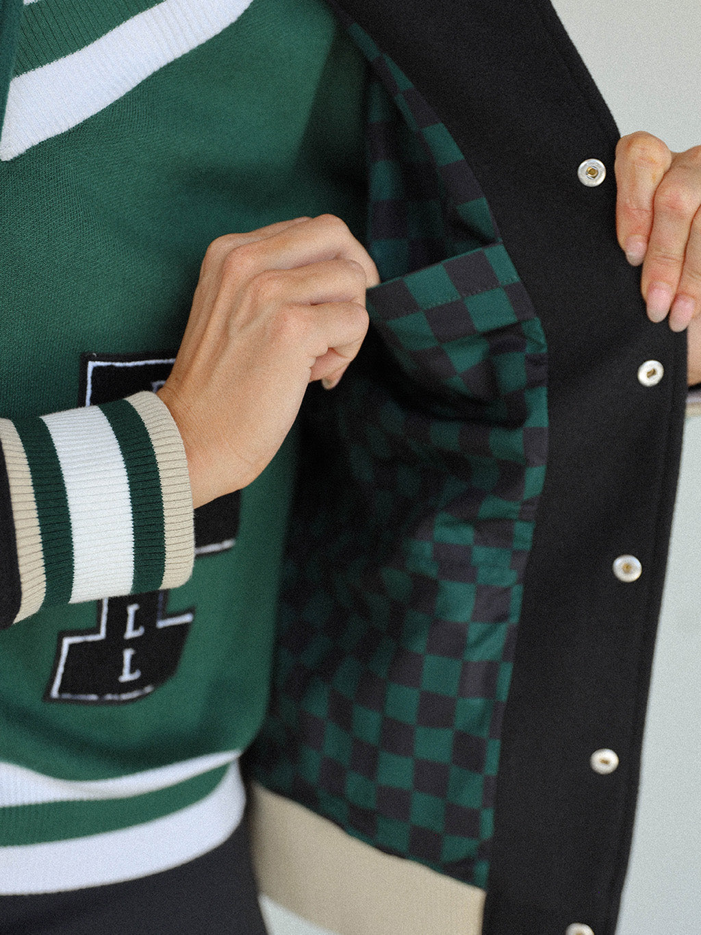 Close-up of the 'Captain's Jacket' from the Royal Collection, showcasing its autumn-inspired hues. Features include exclusive capsule patches, color blocking, black/green checkered lining, and 'Fore All' embroidery on the back. This vintage-inspired varsity jacket combines classic style with modern details, ideal for making a statement in your fall wardrobe.