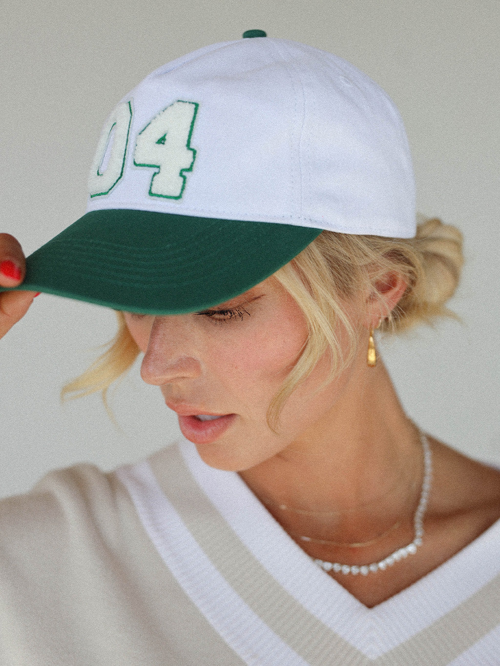 Close-up of the 'Weirsy Hat' from the Royal Collection, inspired by autumn hues. This hat retains the coveted fit of the best-selling Fore Hat but adds a vintage feel with an '04' patch. Combining classic style with an updated design, it's a must-have accessory for any golf enthusiast.