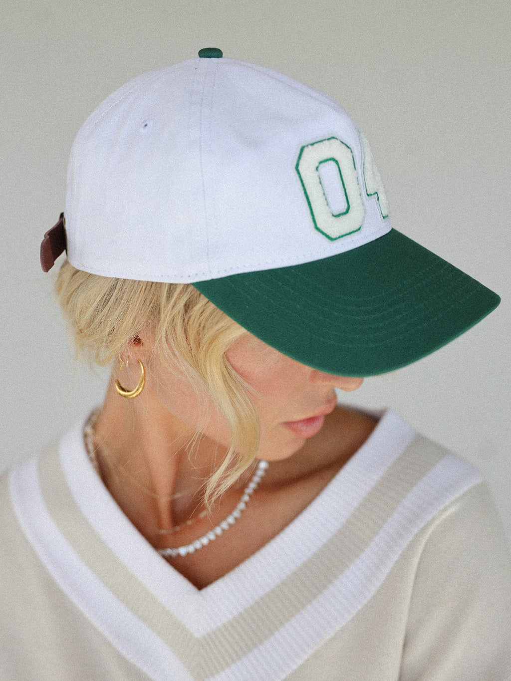 Close-up of the 'Weirsy Hat' from the Royal Collection, inspired by autumn hues. This hat retains the coveted fit of the best-selling Fore Hat but adds a vintage feel with an '04' patch. Combining classic style with an updated design, it's a must-have accessory for any golf enthusiast.