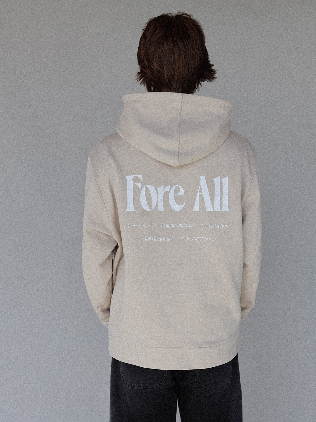 &quot;Close-up of the &#39;Global Hoodie&#39; from the Royal Collection, inspired by autumn hues. This cozy, slightly oversized hoodie features a substantial pocket for golf and personal items and a full-coverage hood. &#39;Fore All&#39; details on the front and back include the classic &#39;Golfing Optional&#39; phrase in five languages. Perfect for combining comfort and global style this season.&quot;