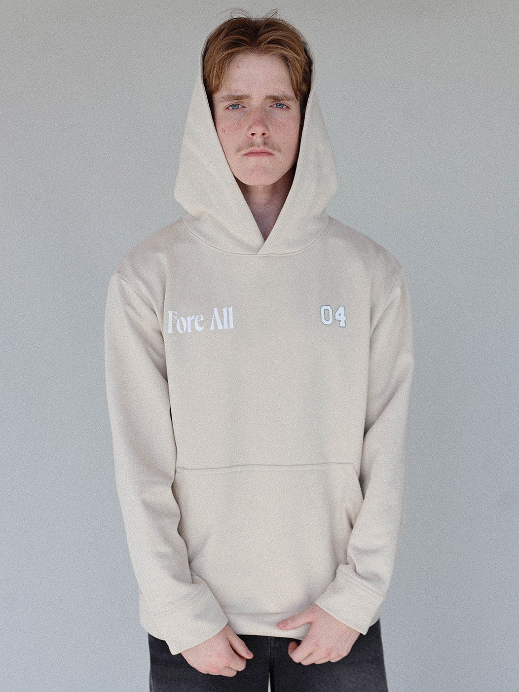 &quot;Close-up of the &#39;Global Hoodie&#39; from the Royal Collection, inspired by autumn hues. This cozy, slightly oversized hoodie features a substantial pocket for golf and personal items and a full-coverage hood. &#39;Fore All&#39; details on the front and back include the classic &#39;Golfing Optional&#39; phrase in five languages. Perfect for combining comfort and global style this season.&quot;