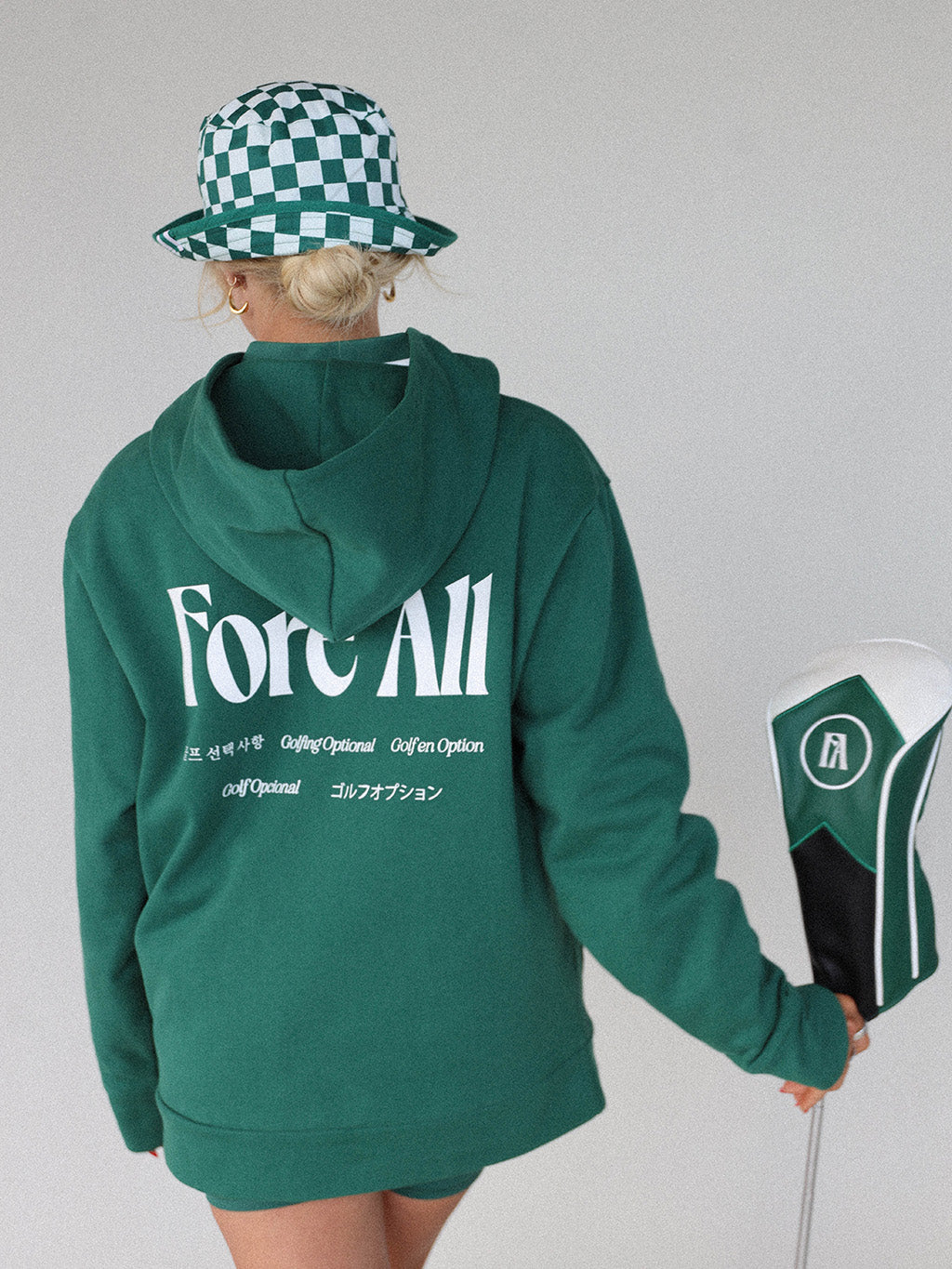 &quot;Close-up of the &#39;Global Hoodie&#39; from the Royal Collection, inspired by autumn hues. This cozy, slightly oversized hoodie features a substantial pocket for golf and personal items and a full-coverage hood. &#39;Fore All&#39; details on the front and back include the classic &#39;Golfing Optional&#39; phrase in five languages. Perfect for combining comfort and global style this season.&quot;